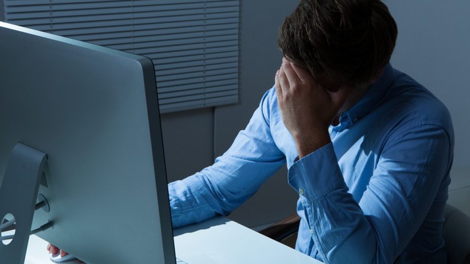 Overstressed Businessman Leaning At Computer Desk
